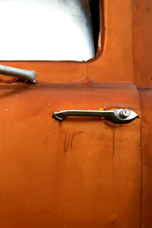 a close up of an old rusted truck door handle, an album cover, by Sven Erixson, unsplash, auto-destructive art, orange body, ripped fabric, body fitted dart manipulation, 1959