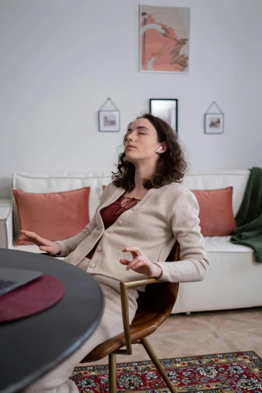 a woman sitting in a chair in a living room, hard breathing, connectivity, in the center of the image, promo image