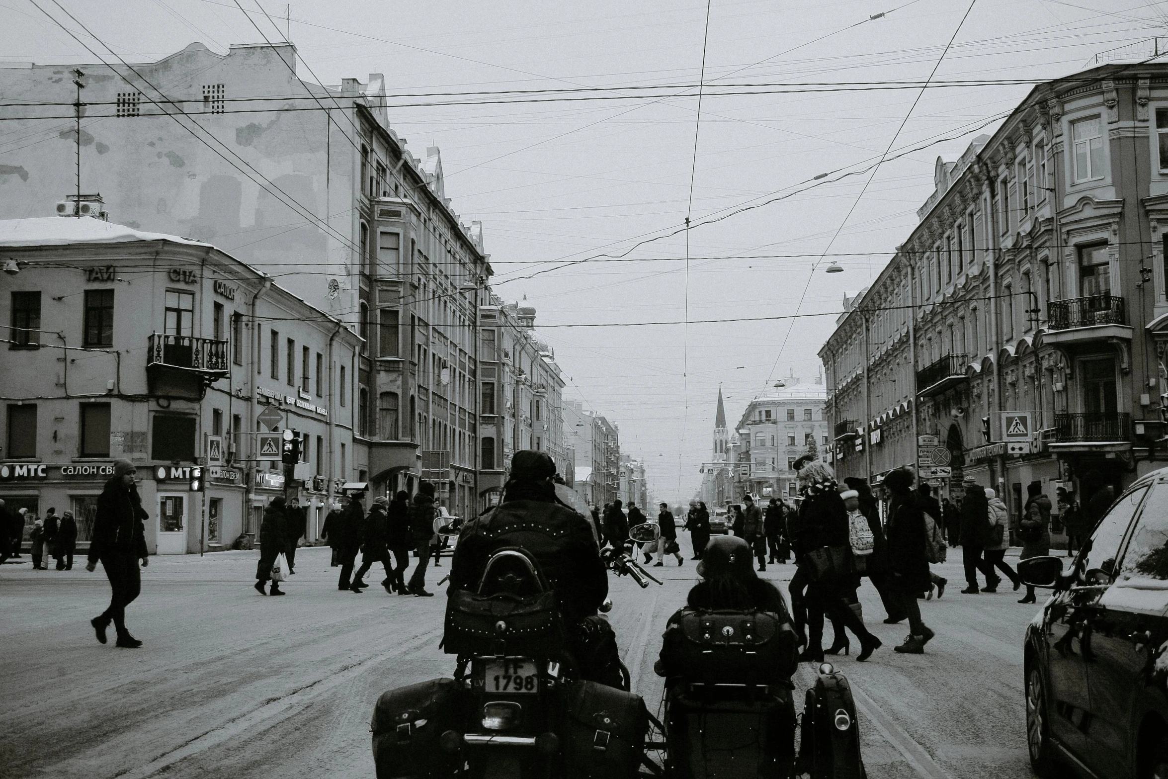 a black and white photo of people walking down a street, by Tamas Galambos, pexels contest winner, motorbike, saint petersburg, winter, old comics in city