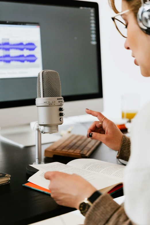 a woman sitting at a desk in front of a computer, trending on pexels, analytical art, rapping into microphone, studious, medium closeup, 1 2 9 7