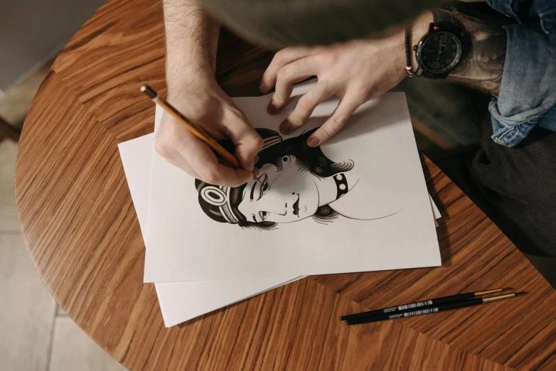 a man is drawing a woman's face on a piece of paper, by Oskar Lüthy, trending on pexels, arbeitsrat für kunst, comic book drawing, hand drawn svg, fan art, on a white table
