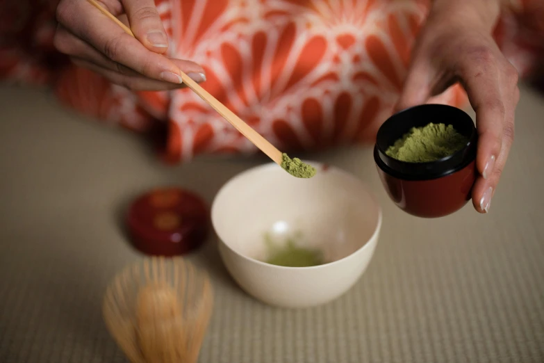 a person holding a bamboo stick over a bowl of matcha, inspired by Kanō Shōsenin, sōsaku hanga, press shot, olive green and venetian red, children's, medium-shot