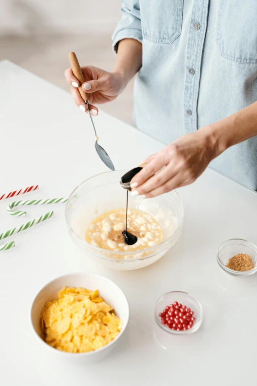 a woman mixing ingredients in a bowl on a table, festive, detailed product image, vanilla, large tall