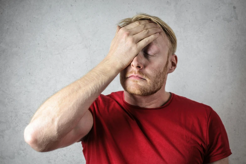 a man in a red shirt covers his eyes with his hands, pexels, depressed dramatic bicep pose, blonde british man, background image, maintenance photo