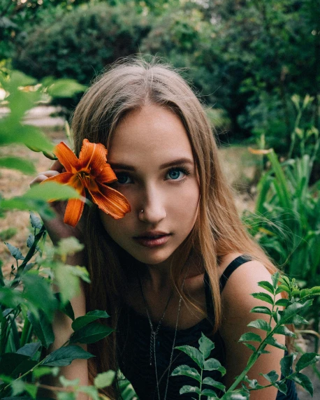 a girl with a flower in her hair, inspired by Elsa Bleda, trending on unsplash, lush greenery, perfect face ), non binary model, posing for a picture