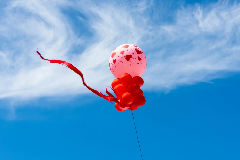 a red and white balloon flying in the sky, an album cover, by Julia Pishtar, pexels contest winner, blue skies, decorations, red ribbon, pink