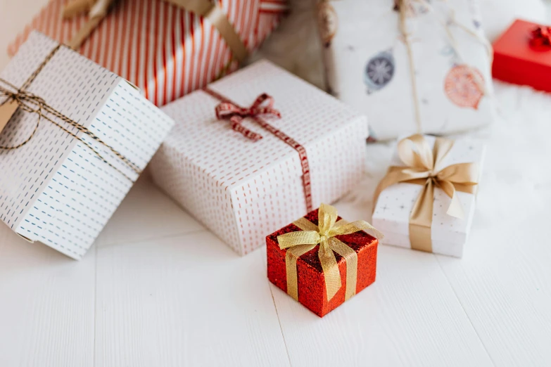 a pile of wrapped presents sitting on top of a table, by Eden Box, pexels contest winner, white and red color scheme, gold, overview, small