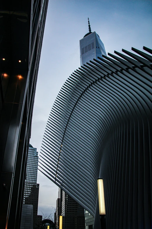 a very tall building sitting in the middle of a city, an album cover, inspired by Zaha Hadid, pexels contest winner, steel archways, black steel buildings, modern new york, calatrava