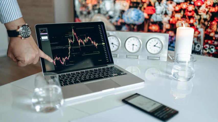 a laptop computer sitting on top of a white table, by Adam Marczyński, trending on pexels, analytical art, displaying stock charts, tubes and gauges, cryptocurrency, an ancient