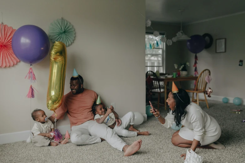 a couple of people that are sitting on the floor, by Carey Morris, pexels contest winner, birthday party, fatherly, as 3 figures, colorized