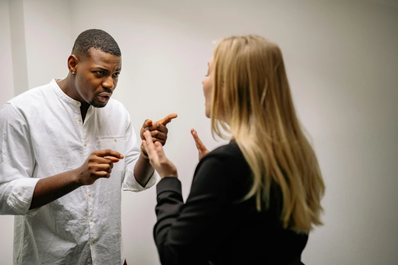 a woman standing next to a man in a white shirt, by Adam Marczyński, pexels contest winner, arguing, black man, pointing index finger, profile image