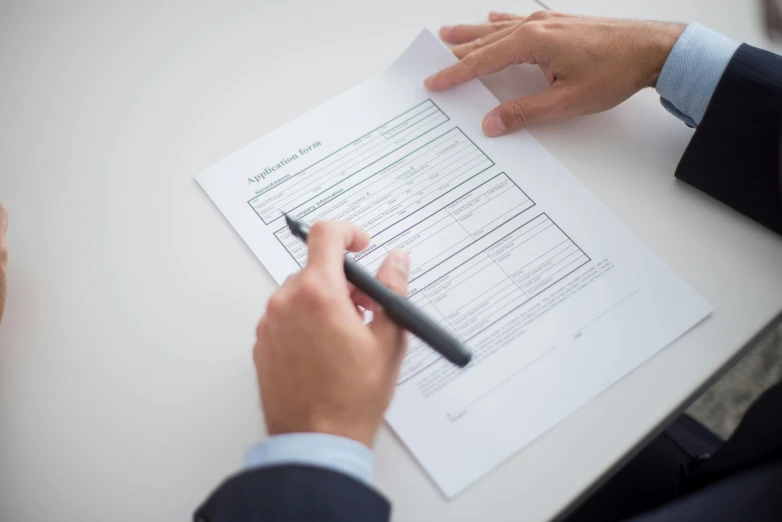 a person sitting at a table with a pen and paper, highly detailed rounded forms, selling insurance, thumbnail, opening shot