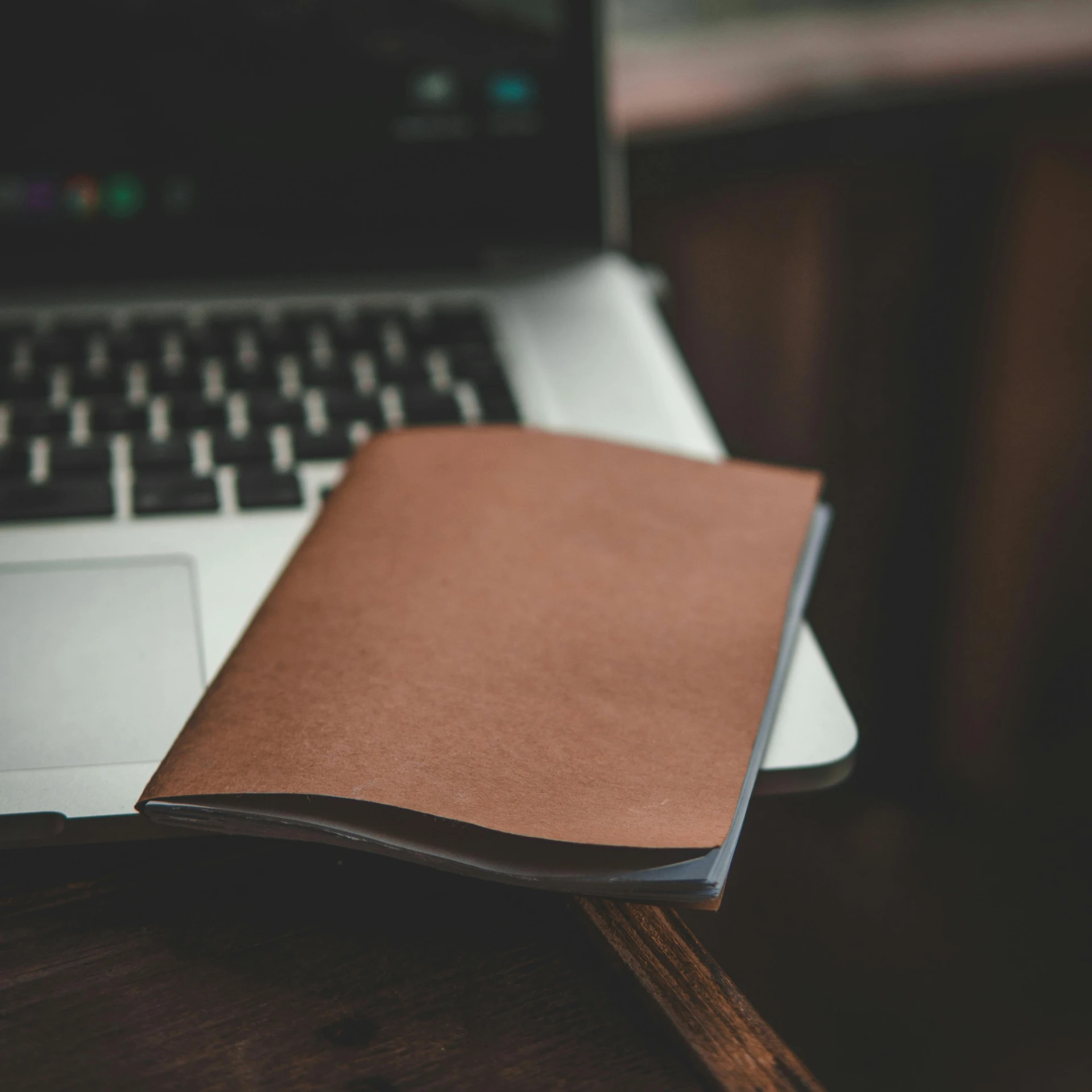 a laptop computer sitting on top of a wooden table, an album cover, unsplash, plush leather pad, scientific paper, brown paper, thumbnail