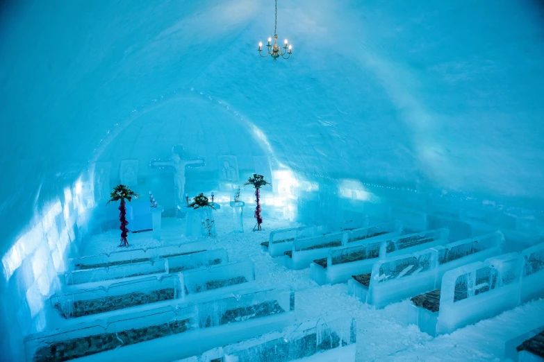 an ice church with a chandelier hanging from the ceiling, fan favorite, in an igloo, deep colour, stone pews