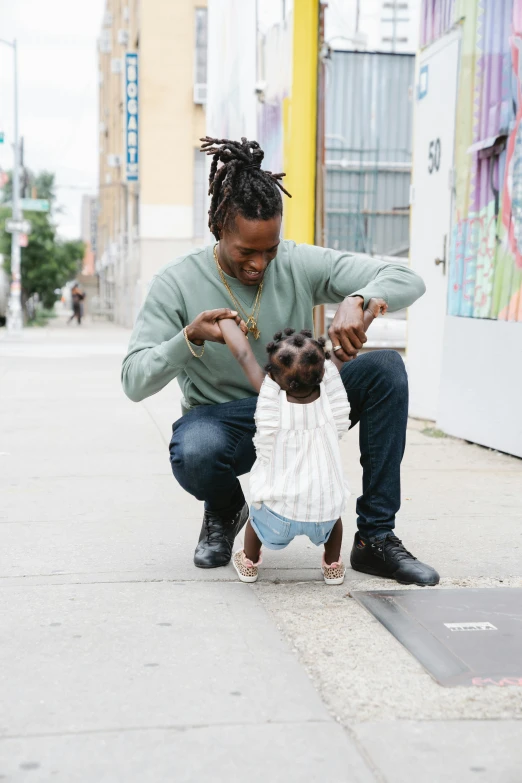 a man kneeling down next to a little girl, trending on unsplash, black arts movement, humans of new york style, playboi carti portrait, in an urban setting, maternal
