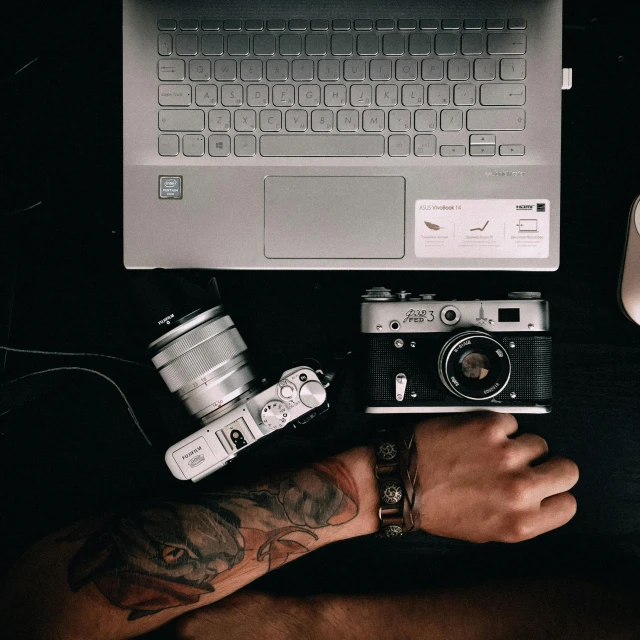 a person holding a camera next to a laptop, a tattoo, trending on pexels, low quality photo, rolleiflex, various posed, high quality image