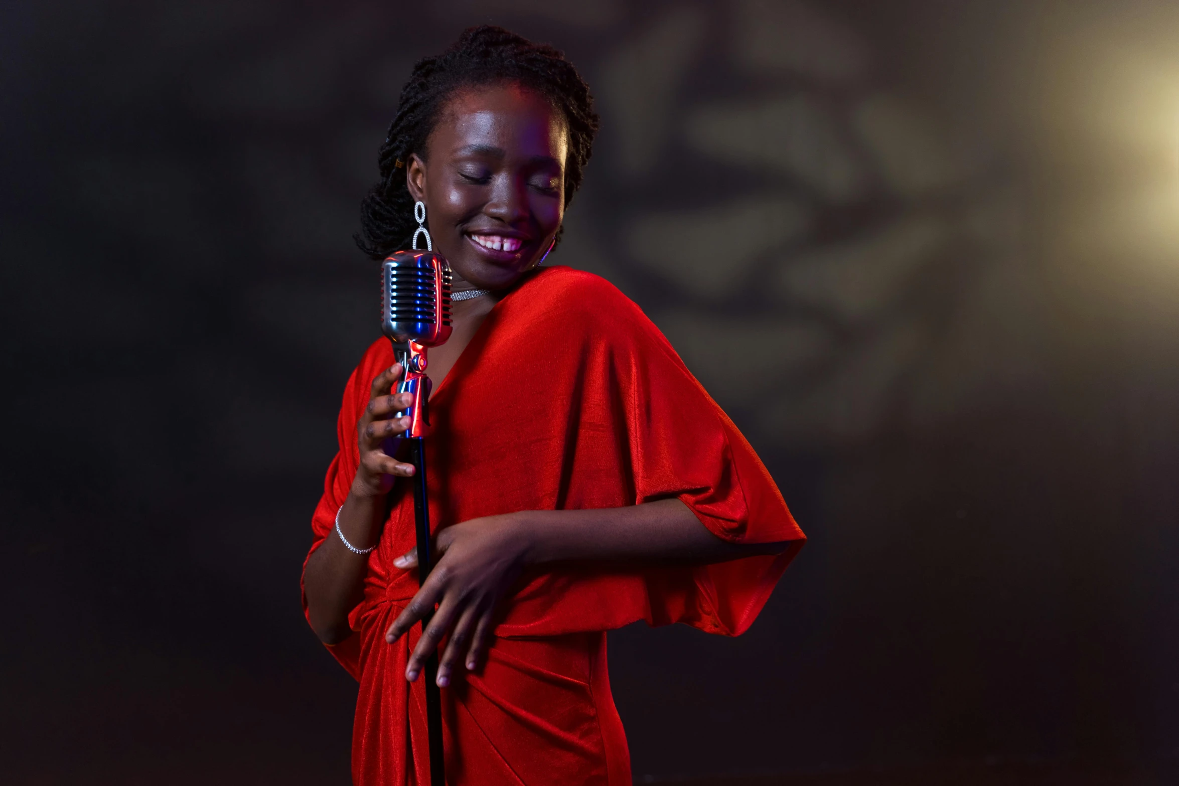 a woman in a red dress holding a microphone, by Ingrida Kadaka, pexels contest winner, adut akech, professional studio photograph, 15081959 21121991 01012000 4k, blues