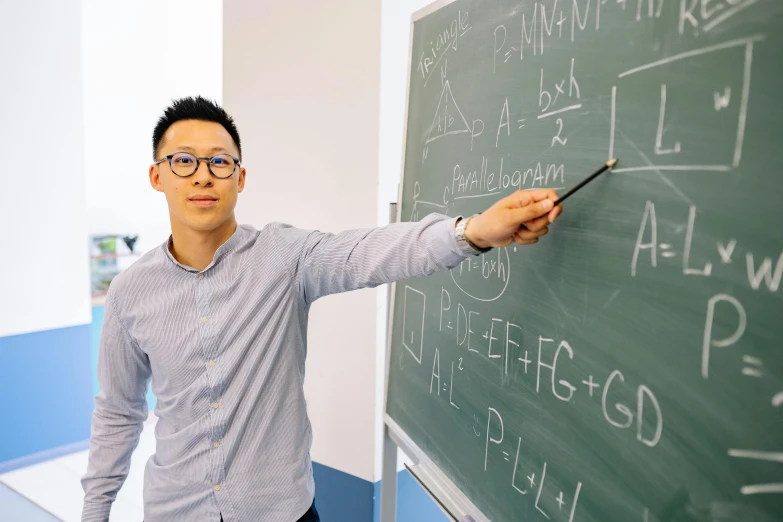 a man standing in front of a blackboard writing on it, by Jang Seung-eop, academic art, lachlan bailey, louise zhang, mathematics and geometry, nerdy music teacher with phd
