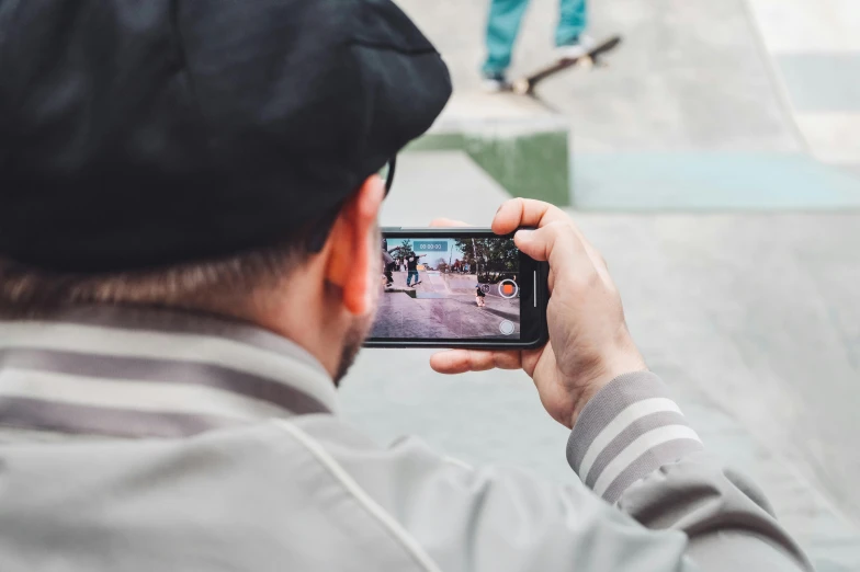 a man taking a picture of a person on a skateboard, pexels contest winner, close up to the screen, back facing the camera, video, next gen