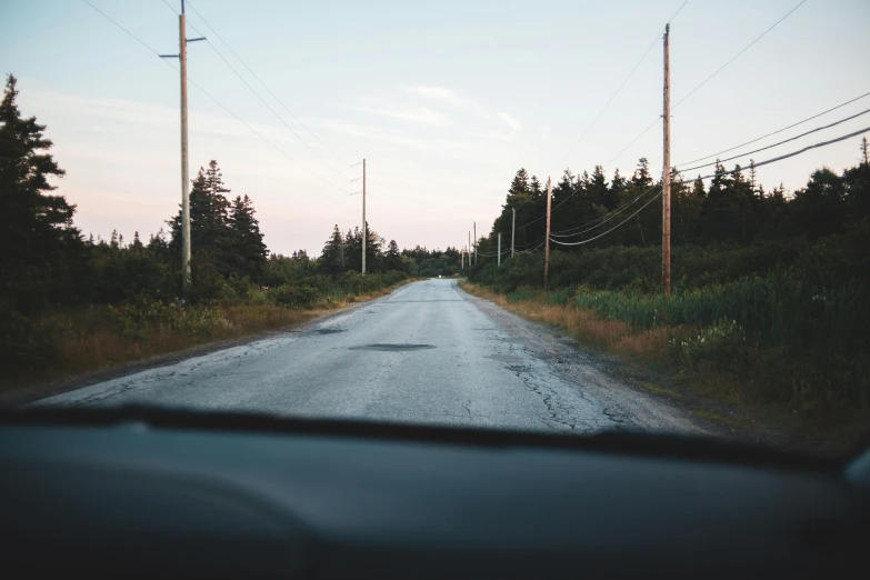 a view of a road through the windshield of a car, an album cover, by Carey Morris, unsplash, 2 5 6 x 2 5 6 pixels, country road, humid evening, powerlines