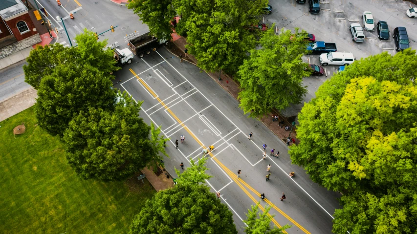 a group of people riding bikes down a street, by Carey Morris, unsplash contest winner, photorealism, an aerial tennis court, intersection, view from a news truck, square lines