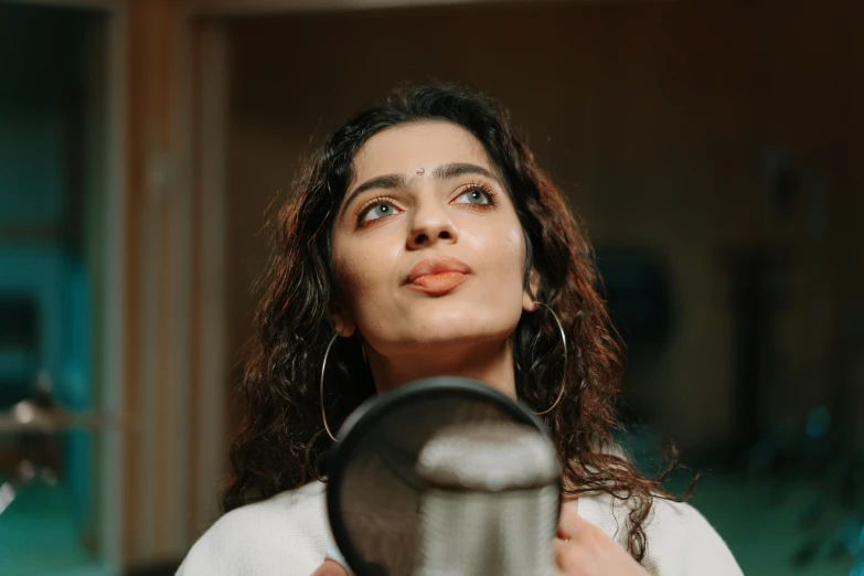 a woman holding a hair dryer in front of her face, an album cover, trending on pexels, hurufiyya, maya ali mage, singing into microphone, profile image, ((portrait))