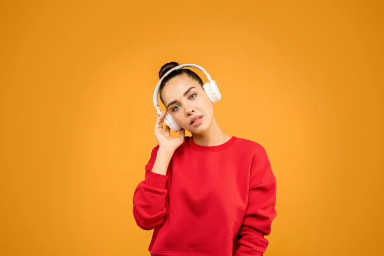 a young woman listening to music with headphones, trending on pexels, white and orange, warm color clothes, avatar image, dua lipa