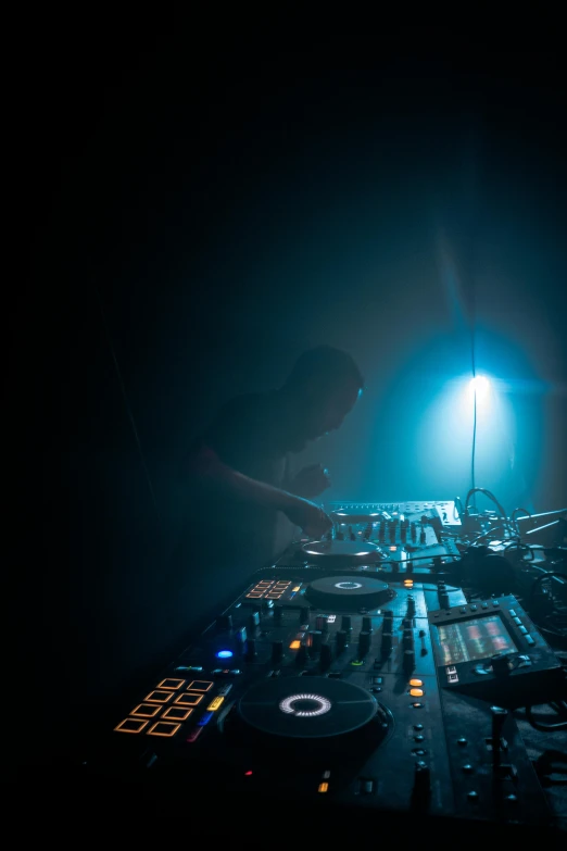 a dj mixing music in a dark room, by Matthias Stom, somber lighting, unknown space, amanda lilleston, hazy