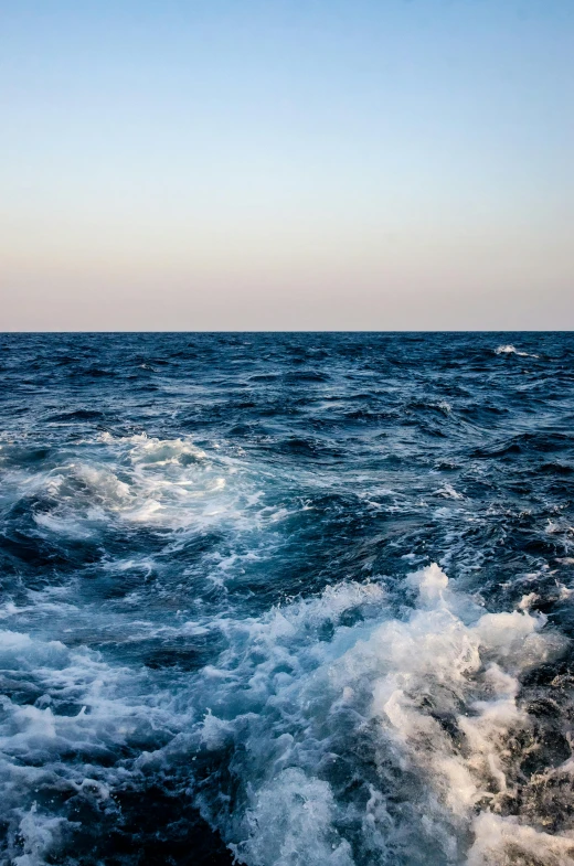 a view of the ocean from the back of a boat, by Daniel Seghers, red sea, turbulent water, early evening, slightly smiling