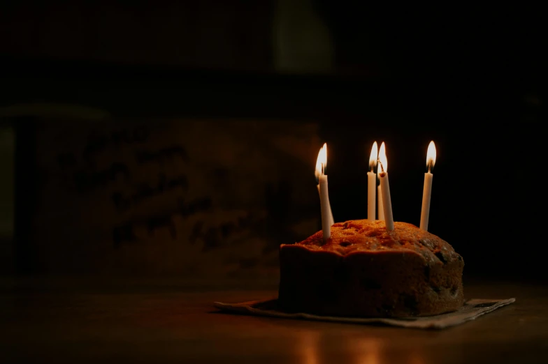 a close up of a birthday cake with lit candles, an album cover, unsplash, background image, dimly lit room, archviz, wooden