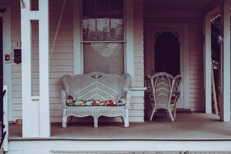 a couple of wicker chairs sitting on a porch, by Carey Morris, pexels contest winner, old couch, retro colour, standing outside a house, white