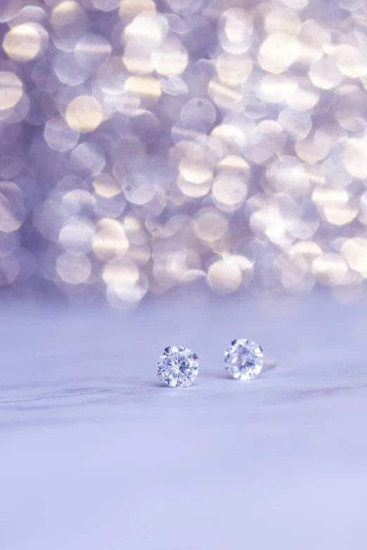 a pair of diamond earrings sitting on top of a table, by Dan Content, trending on pexels, digital art, high key, holiday, 15081959 21121991 01012000 4k, glinting particles of ice