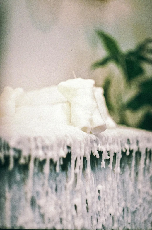 a piece of cake sitting on top of a table, inspired by Elsa Bleda, unsplash, process art, icicles, soap, white, cheesy