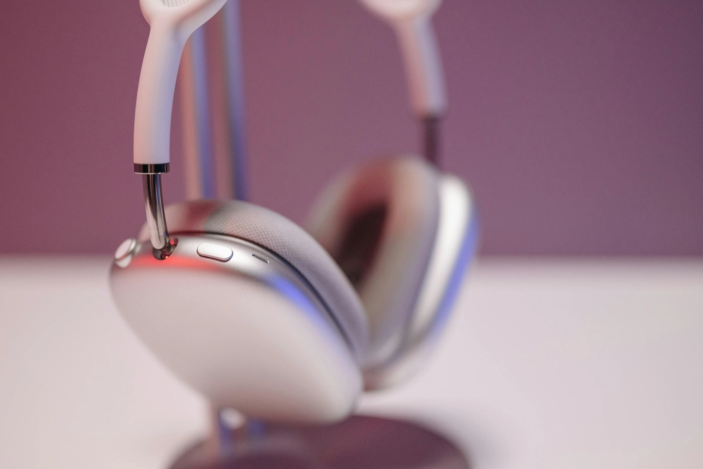 a pair of headphones sitting on top of a stand, a 3D render, trending on pexels, photorealism, white and purple, smooth tiny details, glossy white metal, up-close