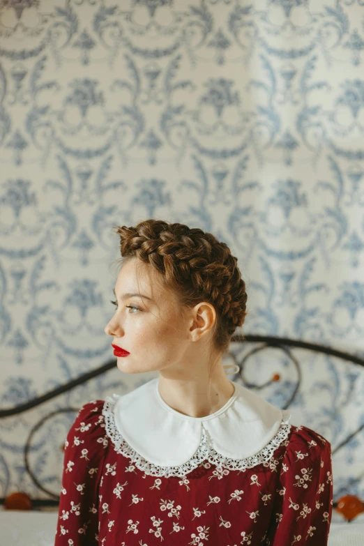 a woman in a red dress sitting on a bed, a portrait, inspired by Sofonisba Anguissola, trending on pexels, rococo, braided hairstyle, 1 9 4 0 s haircut, symmetrical portrait, red lips