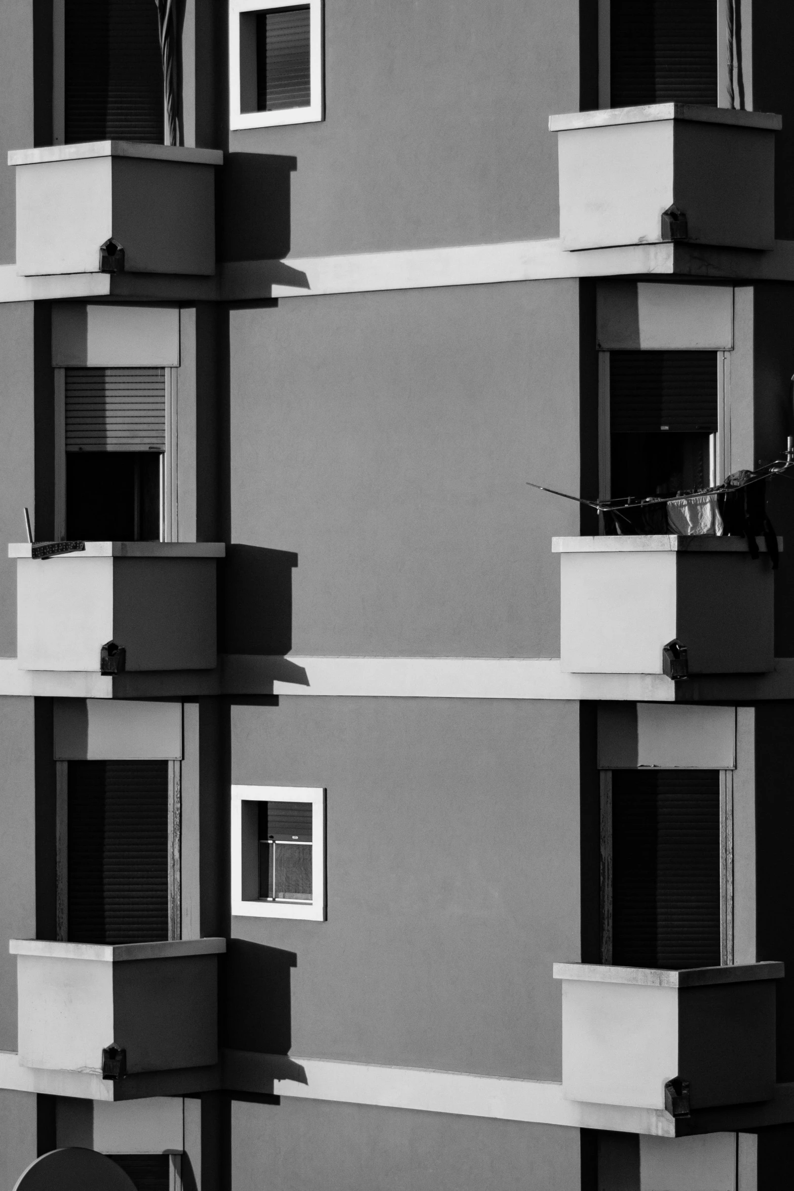 a black and white photo of a tall building, inspired by Arnold Newman, unsplash contest winner, stacked houses, square shapes, window, alessandro barbucci