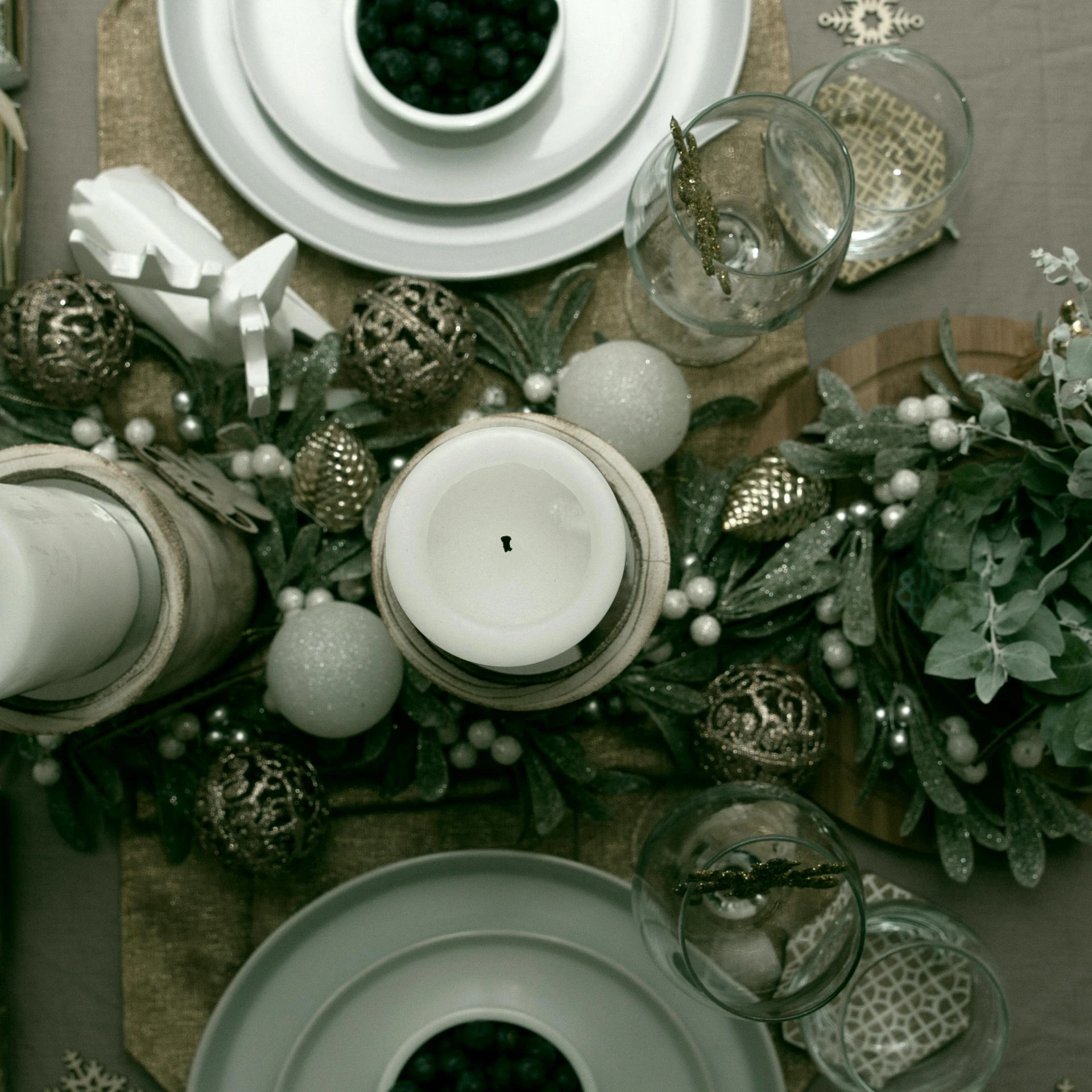 a table is set for a holiday dinner, a colorized photo, by Adam Marczyński, pexels contest winner, silver，ivory, looking down on the camera, mixed materials, romantic greenery