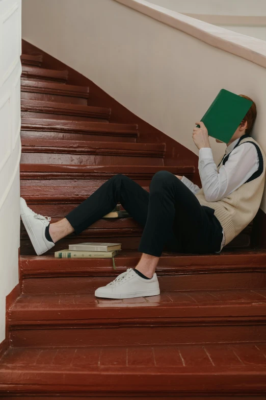 a woman sitting on the stairs reading a book, inspired by Elsa Bleda, trending on pexels, renaissance, portrait of depressed teen, male ulzzang, a green, dunce