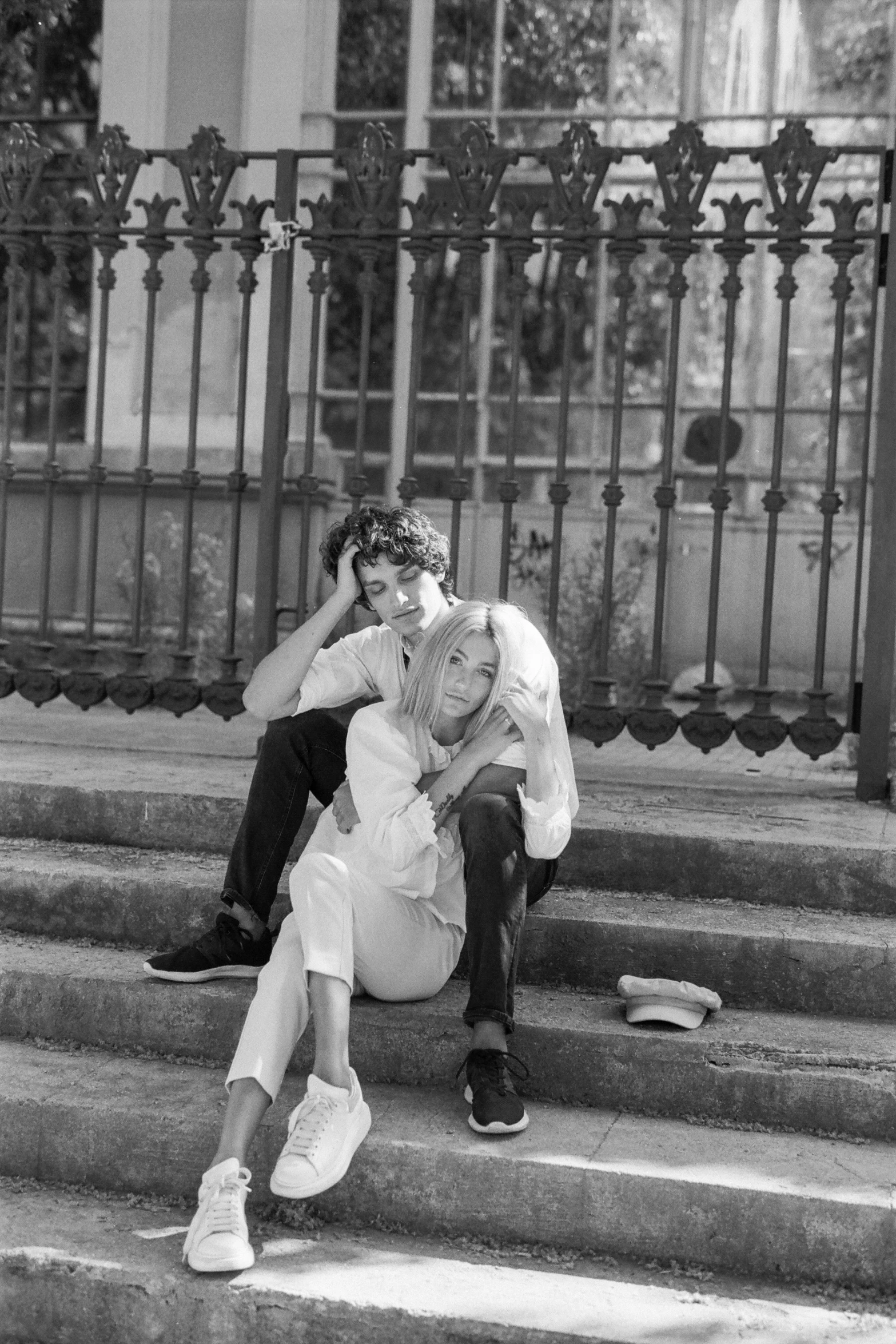 a man and a woman sitting on some steps, a black and white photo, by Sergio Burzi, renaissance, sonic youth, wearing white clothes, riccardo scamarcio, gregoire and manon