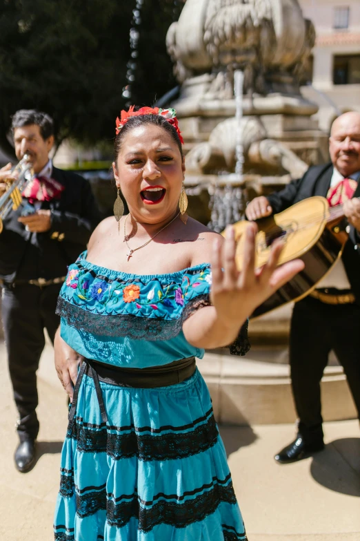 a woman in a blue dress playing a musical instrument, mexican standoff, stands in center with open arms, 2019 trending photo, wedding