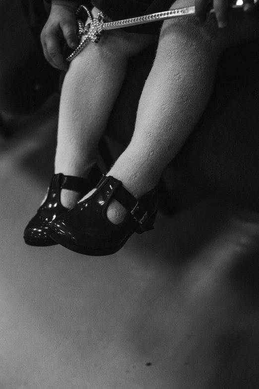 a black and white photo of a baby wearing high heels, inspired by Diane Arbus, tumblr, surrealism, black metal aesthetics, made of rubber, ( ( photograph ) ), concert