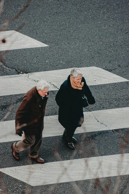 a couple of people that are walking across a street, trending on unsplash, happening, gray haired, square, two male, top - down photo