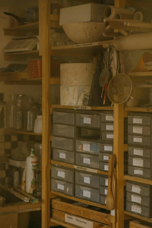 a room filled with lots of drawers and shelves, a picture, renaissance, spanners, cinematic medium shot, hazy, ceramics