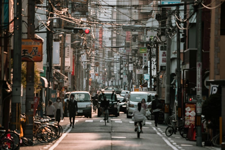 a man riding a bike down a street next to tall buildings, pexels contest winner, ukiyo-e, machines and wires everywhere, people walking on street, dusty street, 🚿🗝📝