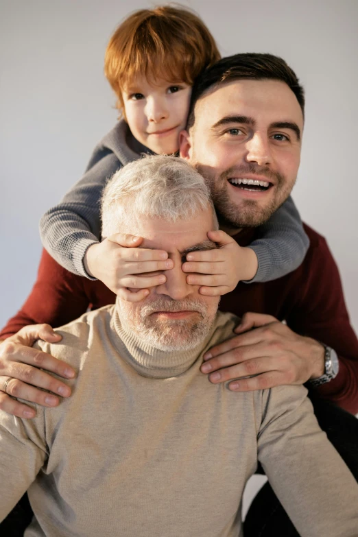 a man holding a little boy on his shoulders, pexels contest winner, some grey hair in beard, two men, square masculine facial features, hide the pain harold