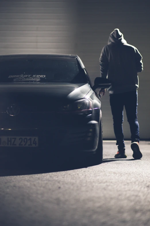 a man standing next to a car in a garage, by Sebastian Spreng, unsplash, wrx golf, menacing!!!, shadowing, large)}]