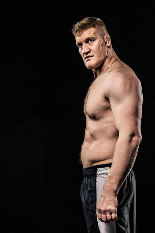 a shirtless man standing in front of a black background, inspired by Sam Dillemans, brock lesnar, jay leno with gray skin, david noren, photo for magazine