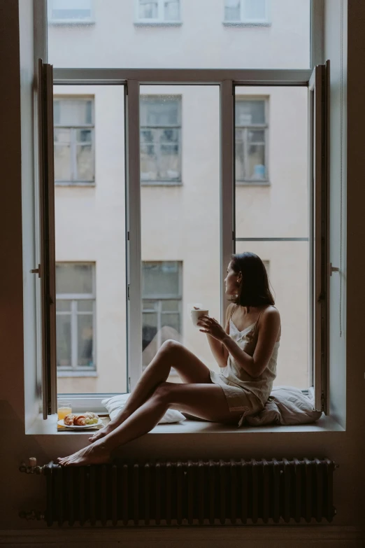 a woman sitting on a window sill reading a book, inspired by Elsa Bleda, pexels contest winner, breakfast, wearing a camisole and shorts, angelina stroganova, evening time