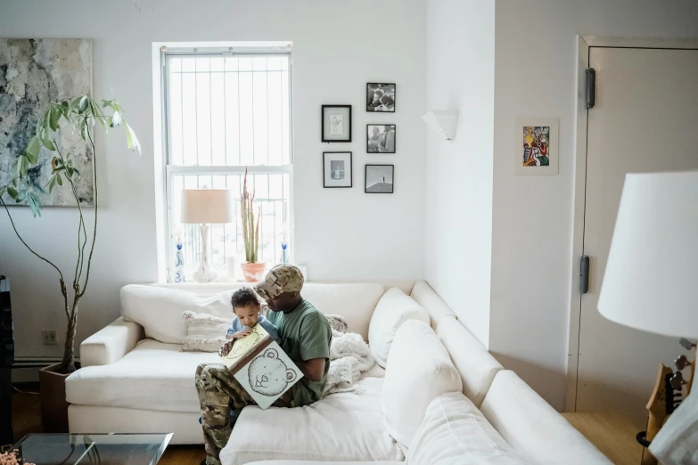 a couple of people that are sitting on a couch, by Samuel Washington Weis, pexels contest winner, father with child, white american soldier, city apartment, ignant