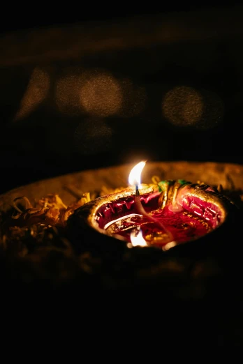 a lit diya on a plate in the dark, pexels, beam of light, hindu ornaments, blessing the soil at night, trending on